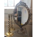 A pair of brass candlesticks 29cm and a brass framed mirror 49cm (3)