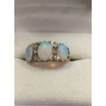A three stone opal ring set in 9ct gold. Size M.