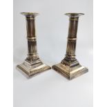 A pair of silver plated candlesticks 16.5cm tall set on square basis with ribbed decoration to body.