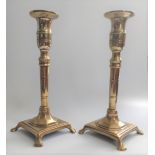 A pair of 19th century brass candlesticks, the interior shafts with prod release sticks. 23cm.