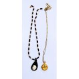 A ladies miniature watch of gold colour, neck chain together with a pearl and black onyx necklace.