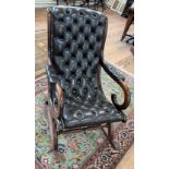A dark mahogany frame rocking chair with dark brown leather and pushed-in buttons, matching padded