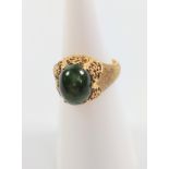 An 18k gold ring set with cabochon jade stone, size H.