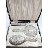 A modern lady's three-piece silver hand mirror and two brushes. In original case.