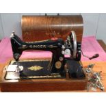 A Singer sewing machine Y2301134 with accessories in original wooden case with key.