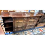 A reproduction mahogany bookcase with open and closed shelving