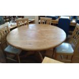A pine circular kitchen table and 4 chairs. Table top has scuff marks. 74 cm high, 178cm diameter.