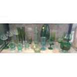 Twenty-one green glass items including a set of three slender drawn-trumpet vases (21)