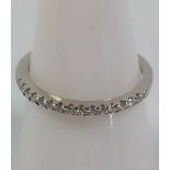 A platinum ring set with approximately fifteen small diamonds. Size "K 1/2". New and unworn
