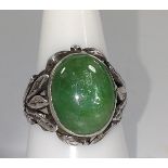 A silver colour metal ring set with a green cabochon stone. Size O. provenance 80 Rose Street