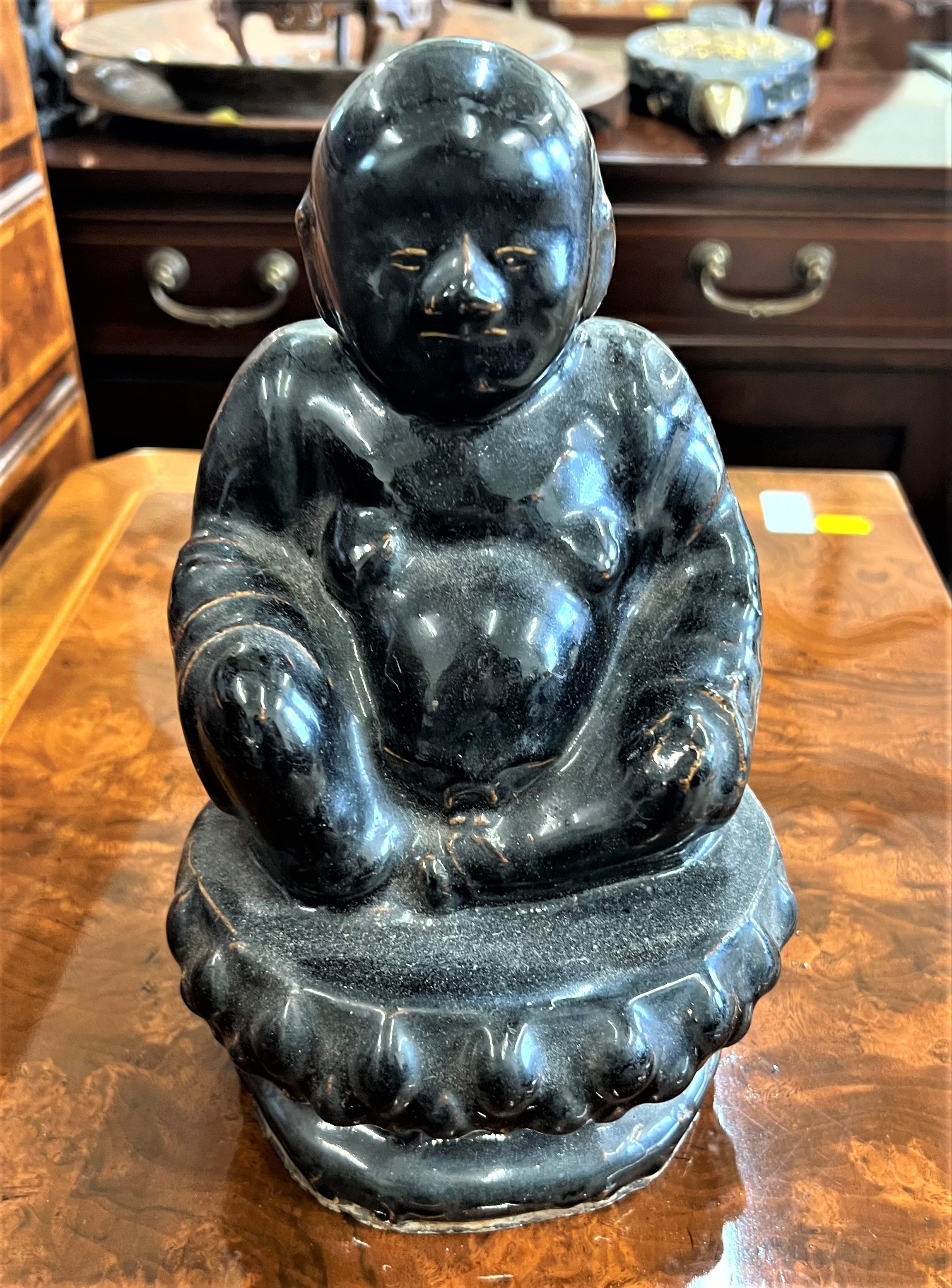 A Vintage Pottery Buddha. Circa 1950. With black glaze. 26cm high. Provenance 80 Rose Street