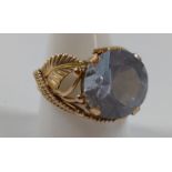 A gold colour metal ring set with a blue stone. Size S. provenance 80 Rose Street Wokingham.