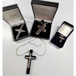 A collection of four silver and coin set crucifix pendants, three with silver chains.