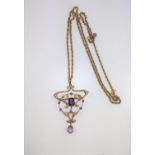 An Art Nouveau pendant set with amethyst and pearls in a gold colour metal frame on a long neck