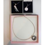 A collection of three silver necklaces with various assorted pendants.