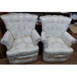 A pair of low seated button back chairs. Ivory pattern with tassel edging at the bottom. On casters.