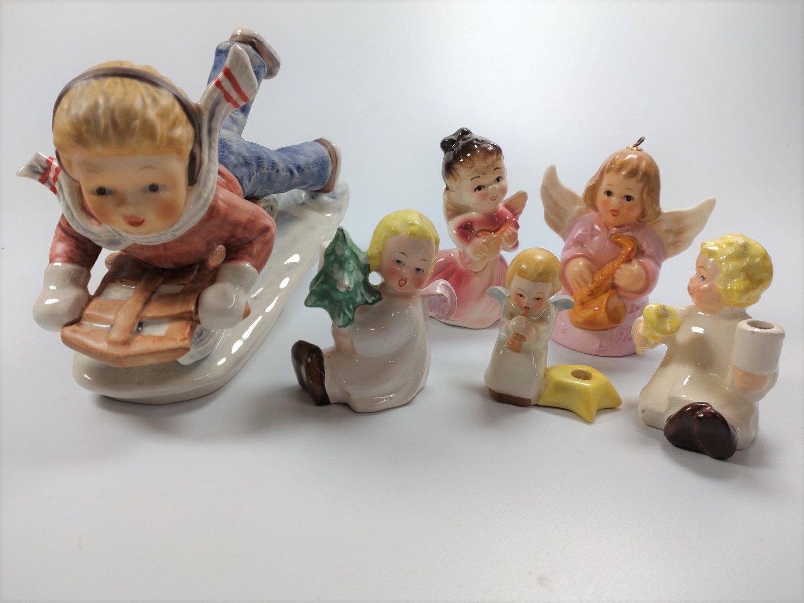 Goebel "Today's Children" figure of a boy on a sled, together with five children Christmas angels
