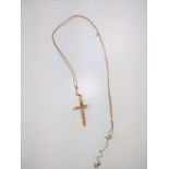 An 18kt gold cross on an unmarked neck chain