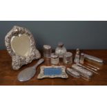 A silver and silver plated dressing table set to include a silver hand mirror, silver lidded and cut