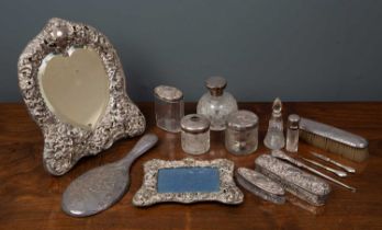 A silver and silver plated dressing table set to include a silver hand mirror, silver lidded and cut