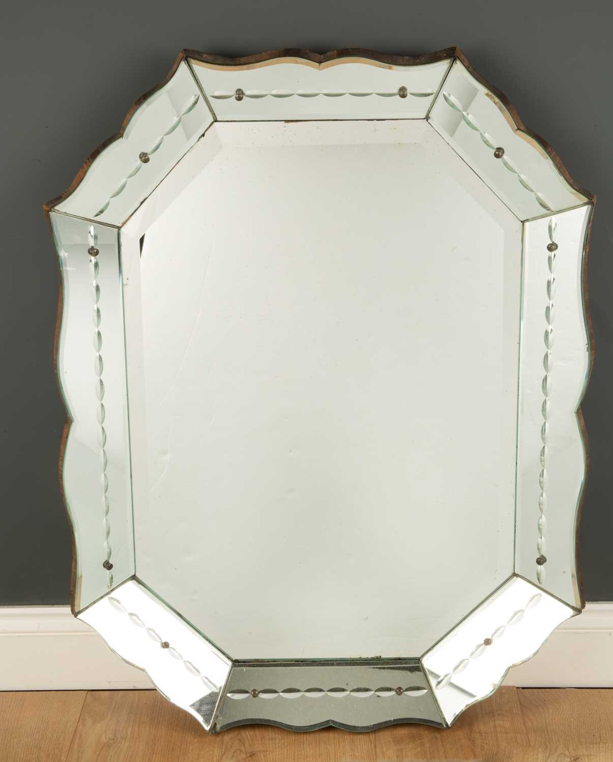 A Venetian style wall mirror with a shaped edge and bevelled glass, 62cm wide x 85cm highCondition