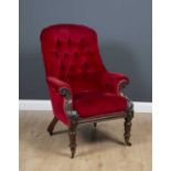 A William IV mahogany framed upholstered armchair with scrolling arms, turned legs and brass