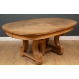 An oak oval extending dining table on scrolled trestle supports and casters, two extra leaves, 121cm