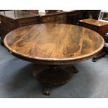 A Victorian rosewood circular dining table, on octagonal central column and circular base