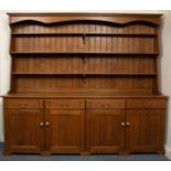 A late 20th century oak dresser, the three tier rack above four short drawers and four cupboard