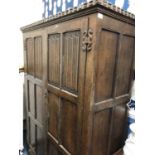 An antique oak two door cupboard or wardrobe with carved decoration, 127cm wide x 54cm deep x