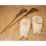 A pair of vintage Lacrosse sticks with wooden handles and string and leather nets, 112cm long