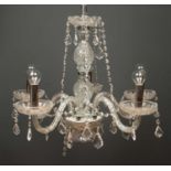 A modern five branch cut glass chandelier with chrome fittings, with a layer of drop pendants around