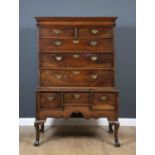 An 18th century walnut chest on stand with nine drawers, brass handles and cabriole legs and