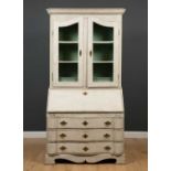 A white painted bureau bookcase the pair of glass doors over two shelves and two short drawers, drop