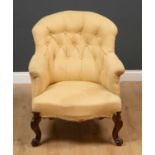 A Victorian upholstered armchair with scrolling legs and button upholstery, 69cm wide x 63cm deep