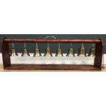 Eight antique chiming bells mounted on a 20th c stand 91cm in length