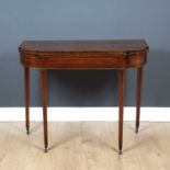 A 19th century mahogany and satinwood line inlaid fold over tea table the shaped front with square