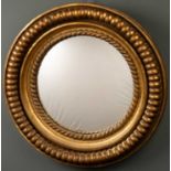 A giltwood circular mirror, the concave mirror plate within two bands of rope twist carved frame,
