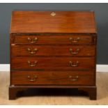 A George III mahogany bureau, the fall front opening to reveal pigeon holes and short drawers, above