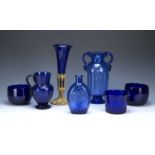 Collection of glassware consisting of cobalt and other blue glass, a tall trumpet vase on an gilt