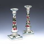 Pair of Weymss candlesticks decorated with fruit and leaves, impressed marks to the base alongside