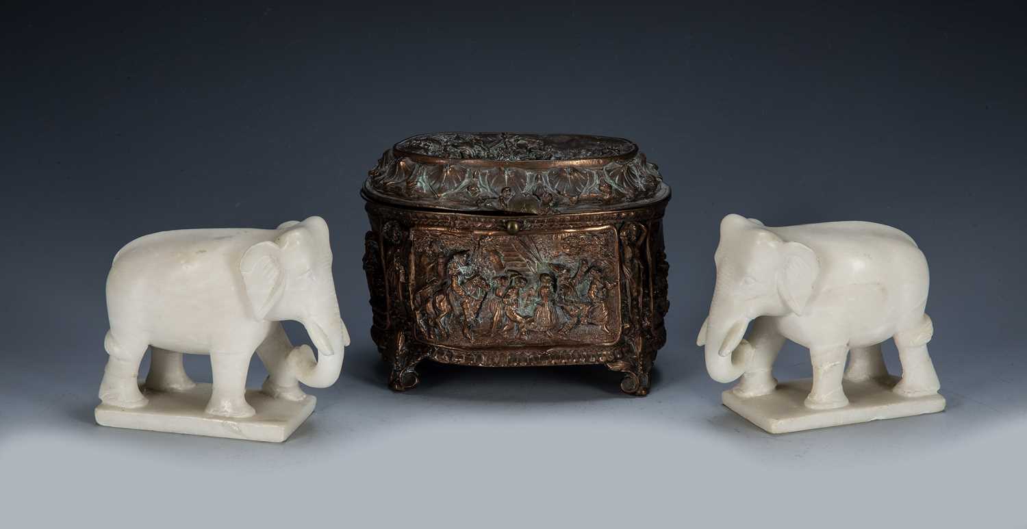 Pair of alabaster model elephants Indian, 10cm long, and an oval copper casket with 'Teniers' type