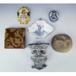 Two Delft blue and white glazed wall mounts/brackets each modelled as a head, 8cm and 16cm high, a