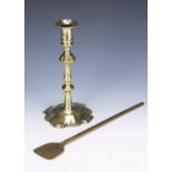 Brass single candlestick early 18th Century, 22.5cm high and a brass flat head ladle, 31cm long (2)