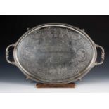Large oval silver presentation tray with twin handles, standing on four feet, the centre