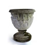 Reconstituted garden urn of classical form with mask-head and fluted decoration with pedestal