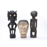 Tribal interest, carved wooden head, possibly Indonesian with inset bone eyes, together with two