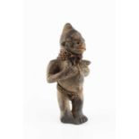 A Yoruba Shango clay figure, in the form of a man with sennit girdle and neck decoration, 22cm high