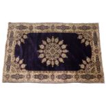 A Kashmiri purple ground rug with central lotus bud medallion within a multiple polychrome border,