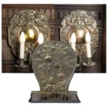 A brass Arts & Crafts style candle stand, the shaped back embossed with figs and leaves, the